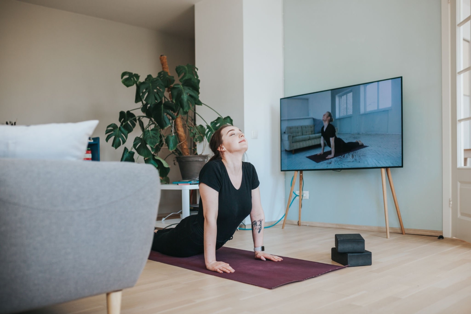 Adult woman in upward facing dog position during online yoga lessons